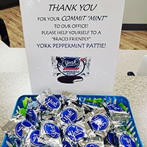 Orthodontic office thank you sign with blue wrapped candies in display tray.