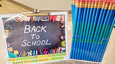 Back to school display with chalk sign and colorful pencils on table.