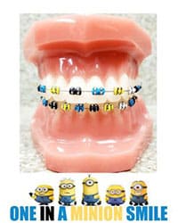 Dental model displaying colorful braces with minion characters, orthodontic treatment example.