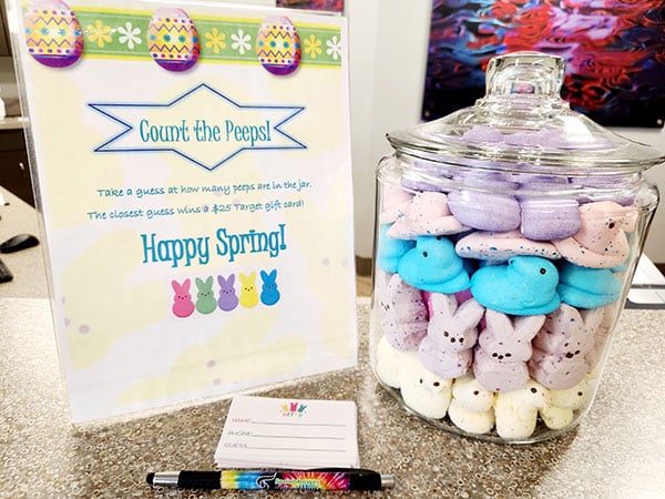 Spring-themed orthodontic office display with colorful cupcakes and "Count the Treats" game sign.