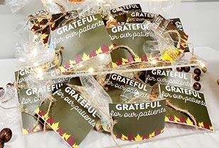 Multiple "Grateful" branded packets and materials scattered on white surface for orthodontic patient education.