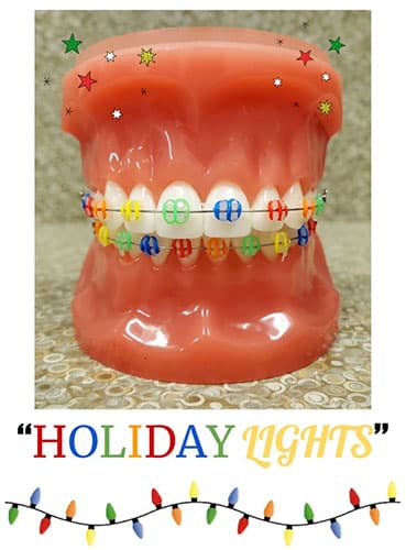 Red ceramic holiday lights decoration with colorful string lights wrapped around middle, festive seasonal display
