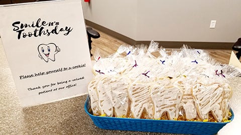 Orthodontic office gift basket with packaged treats and branded Spoonhower Orthodontics signage on display.