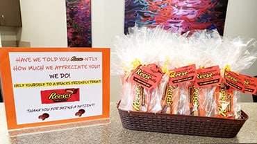 Orthodontic office appreciation display with thank you sign and Reese's candy basket on counter.