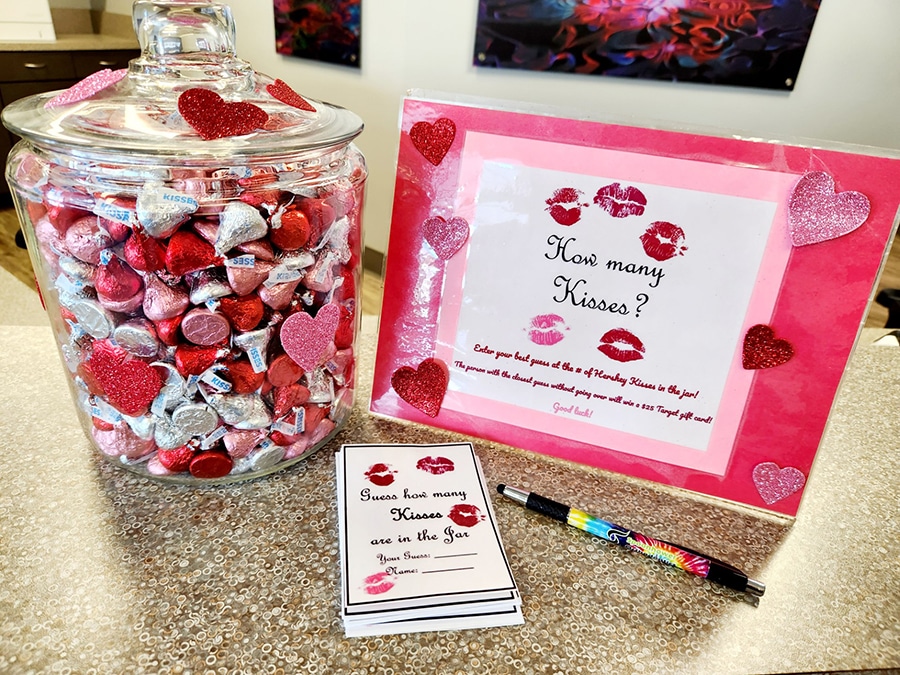 Valentine's Day gift set with candy jar, pink box, and card on counter display.